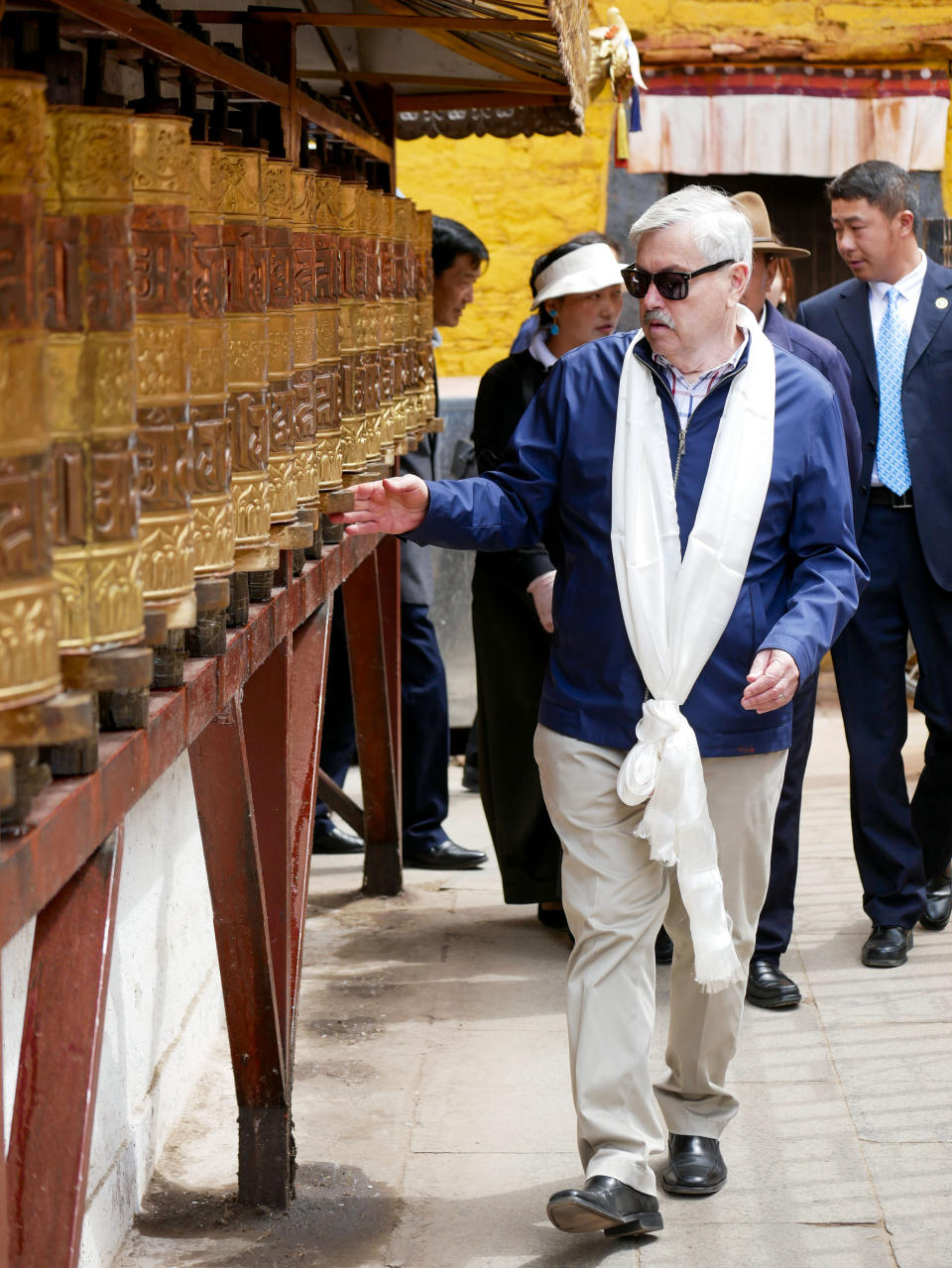 In this photo taken May 23, 2019, and released by the U.S. Embassy in Beijing, U.S. Ambassador to China Terry Branstad rotates prayer wheels in Lhasa in western China's Tibet Autonomous Region. The U.S. ambassador to China urged Beijing to engage in substantive dialogue with exiled Tibetan Buddhist leader the Dalai Lama during a visit to the Himalayan region over the past week, the Embassy said Saturday. (U.S. Mission to China via AP)