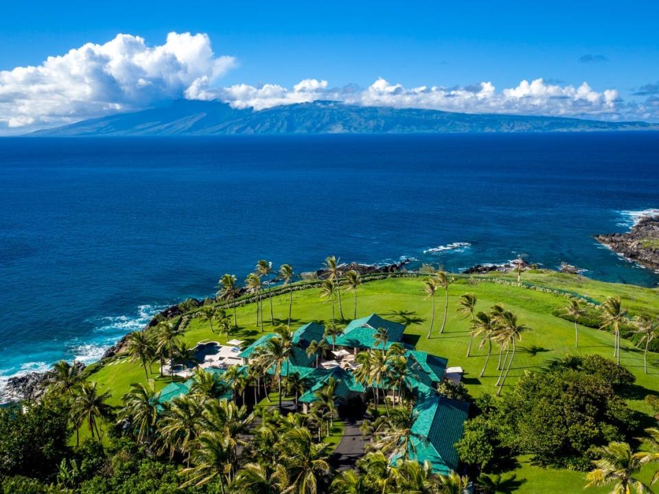 aerial view of a home surrounded by the ocean on one side in Hawaii