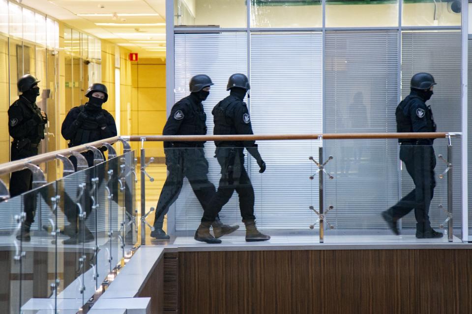 FILE- In this file photo taken on Thursday, Dec. 26, 2019, Russian security officers walk at the Foundation for Fighting Corruption office in Moscow, Russia. A court in Moscow has ruled Tuesday April 27, 2021, to restrict activities of an organization founded by Russia's imprisoned opposition leader Alexei Navalny, pending a ruling on whether it should be outlawed as an extremist group. The Moscow City Court's decision to restrict activities of Navalny's Foundation for Fighting Corruption came amid a sweeping crackdown on President Vladimir Putin most prominent critic and his allies. (AP Photo/Alexander Zemlianichenko, File)