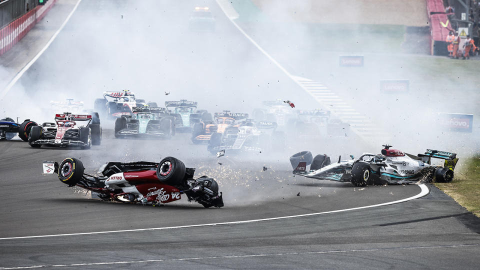 Zhou Guanyou's F1 car is seen sliding off the track upside down after a collision with George Russell at the British GP.