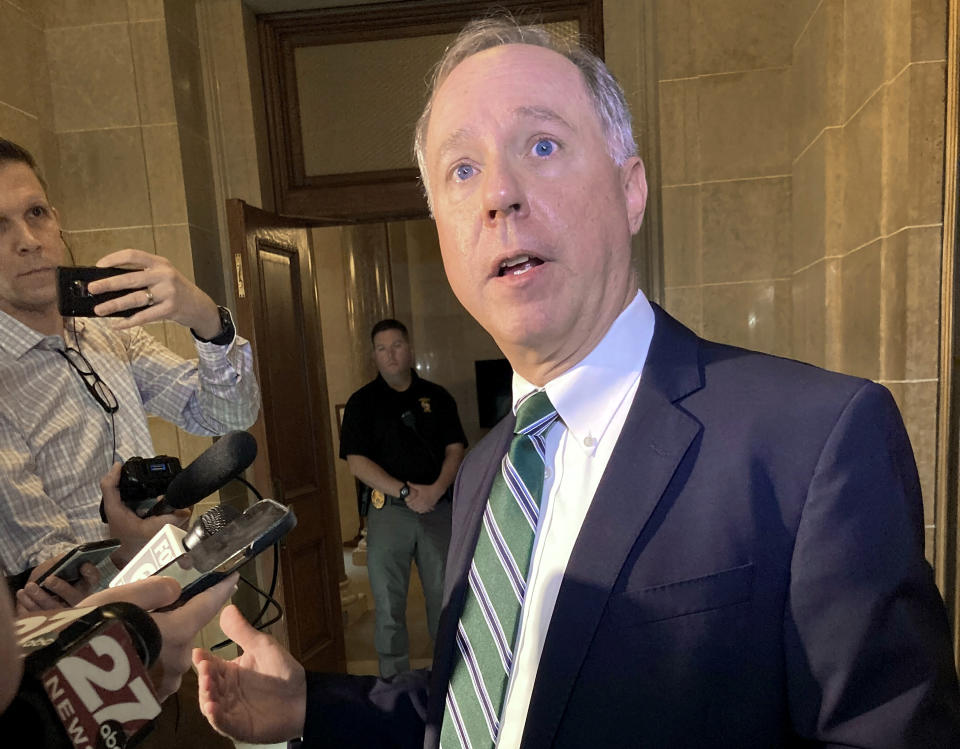 Robin Vos speaks to reporters outside a government building.