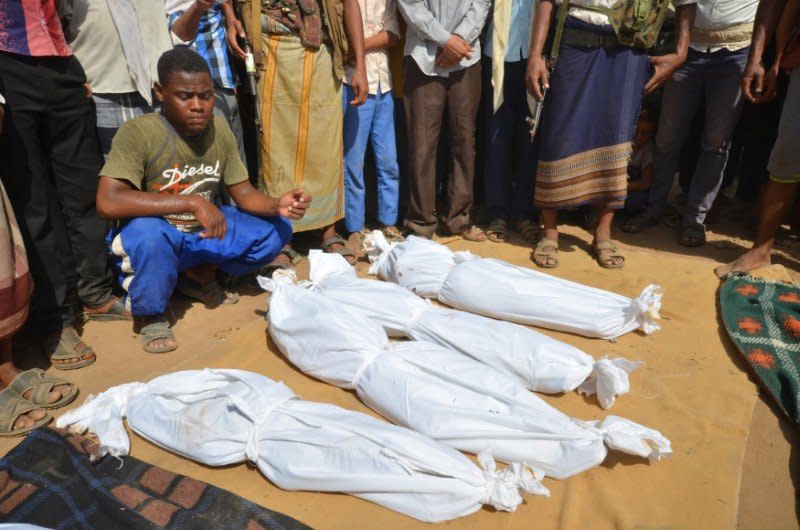 A man sits as others stand near the wrapped up bodies of children from the same family, one day after they were killed in a Saudi-led air strike on their house in Bajil district of the Red Sea province of Houdieda, Yemen October 8, 2016. REUTERS/Abduljabbar Zeyad