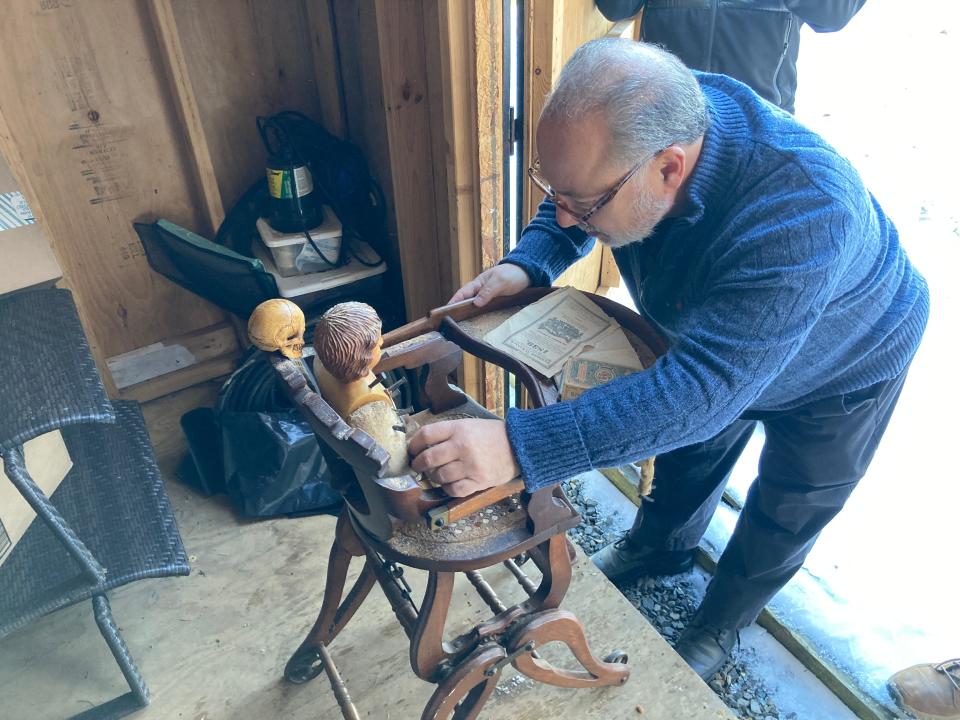 Ed Crimi inspects an antique doll whose owner claims is haunted. Crimi acquired the doll for his collection at the Vampire Art Museum and Paranormal Activity in Buckingham.