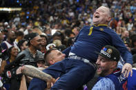 Denver Nuggets head coach Michael Malone is hoisted up by fans after the team won the NBA Championship with a victory over the Miami Heat in Game 5 of basketball's NBA Finals, Monday, June 12, 2023, in Denver.
