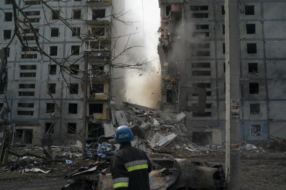 FILE - A firefighter looks at a part of a wall falling from the residential building that was heavily damaged after a Russian attack in Zaporizhzhia, Ukraine, Sunday, Oct. 9, 2022. Russia has declared its intention to increase its targeting of Ukraine’s power, water and other vital infrastructure in its latest phase of the nearly 8-month-old war. (AP Photo/Leo Correa, File)