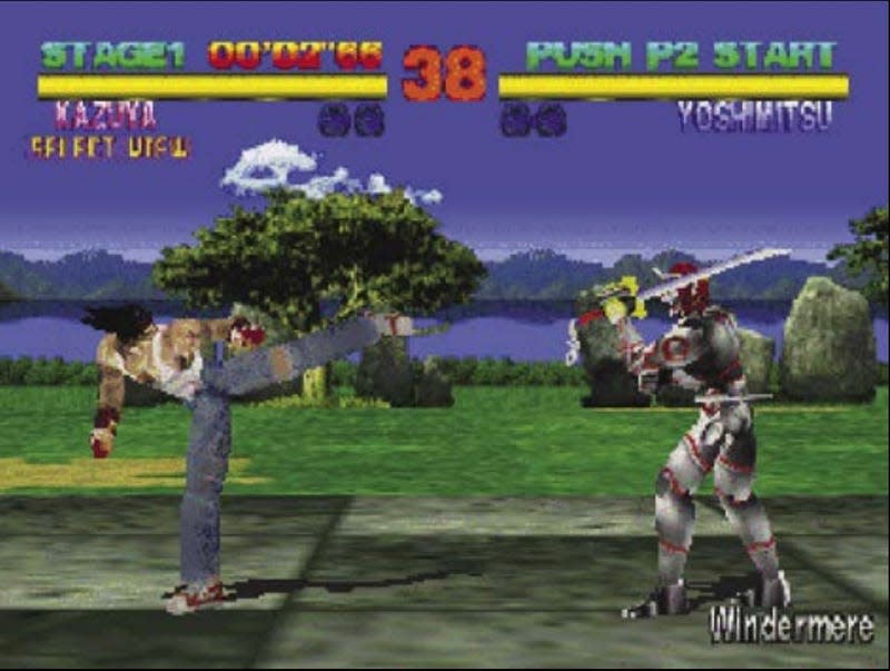 A screenshot of Tekken depicting characters Kazuya and Yoshimitsu fighting with trees, a lake, and mountains in the background.