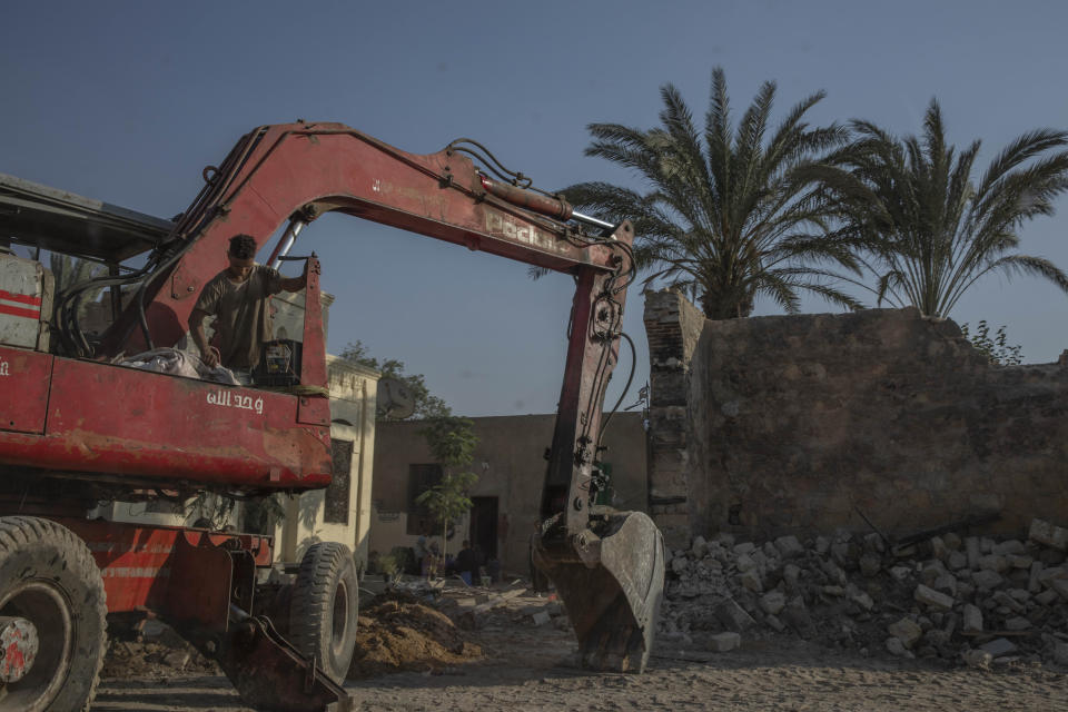 Construction workers knock down walls of family mausoleums to clear way for a new highway running through the historic Northern Cemetery in Cairo, Egypt, Tuesday, July 21, 2020. Dozens of graves have been partially or fully destroyed as the government builds two large expressways through the City of the Dead, a UNESCO World Heritage Site. Authorities say no registered monuments have been harmed, but preservationists have raised alarm that graves of historical value are being lost and that the multilane highways tear apart the fabric of a historic necropolis that has remained intact for centuries. (AP Photo/Nariman El-Mofty)