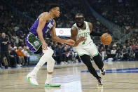 Boston Celtics' Jaylen Brown (7) drives to the basket against Milwaukee Bucks' Giannis Antetokounmpo during the first half of an NBA basketball game Thursday, March 30, 2023, in Milwaukee. (AP Photo/Aaron Gash)