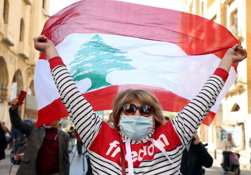 FILE PHOTO: A demonstrator holds up a national flag during a protest in Beirut