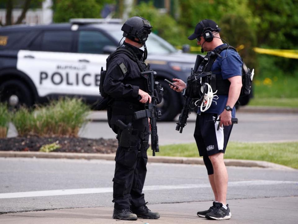 Police officers secure the scene after a shooting at the Tops supermarket in Buffalo on the weekend.  (Jeffrey T. Barnes/Reuters - image credit)