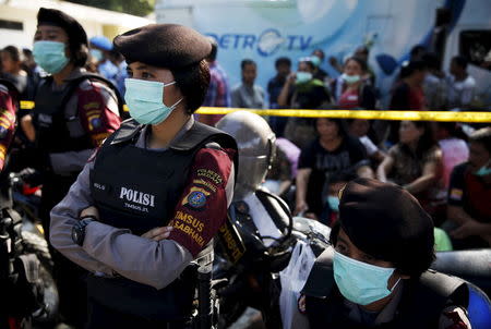 Indonesian police women stand guard near relatives of the victims of an Indonesian military C-130 Hercules transport plane that crashed into a residential area, outside the Adam Malik hospital in Medan, Indonesia North Sumatra province July 2, 2015. REUTERS/Beawiharta