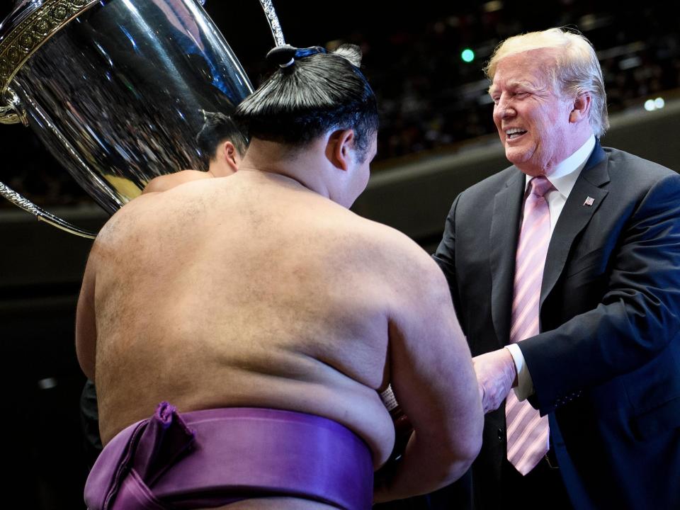 President Donald Trump presented a special US-made trophy to the winner of a sumo tournament on Sunday as he got a taste of one of Japan’s most treasured cultural institutions.The honour given to President Trump was part of a charm offensive by Japanese Prime Minister Shinzo Abe as he courted Mr Trump with three things close to the American leader’s heart: wrestling, cheeseburgers and golf.Sumo diplomacy, to sum it up.The president, first lady Melania Trump, Mr Abe and his wife, Akie, joined an estimated 11,500 fans at Ryogoku Kokugikan Stadium to watch massive and muscular men, in bare feet and loin cloths, battle for supremacy in a small ring of dirt.At the match’s end, Mr Trump stepped into the ring and presented the eagle-topped “President’s Cup” to the champion, Asanoyama.Mr Trump, the first American president to participate in such a ceremony, said later it was an “incredible evening.”“That was something to see these great athletes,” President Trump said before having dinner with the Abes at a hibachi restaurant.Trump’s four-day state visit to Japan is designed to demonstrate the strength of the US-Japan alliance.Earlier on Sunday, Mr Abe warmly welcomed Trump to Mobara Country Club, south of Tokyo, for a round of golf, their fifth since Trump became president.Mr Abe is trying to placate Trump amid growing US-Japan trade tensions and the threat of auto tariffs.Japan also is contending with the continued military threat from North Korea, a concern seemingly heightened by Mr Trump’s apparent dismissal of the North’s recent tests of short-range missiles that could strike Japan.Despite several antagonistic presidential tweets, the day was all about keeping President Trump happy.First it was golf. Mr Trump and Mr Abe played 16 holes, joined by Japanese pro Isao Aoki. On the lunch menu: double cheeseburgers made with US beef.Then Prime Minister Abe introduced Mr Trump to Japan’s ancient sport of sumo wrestling , which Trump has said he finds “fascinating”.Loud applause greeted Mr Trump as he entered the arena and took his seat a few rows behind the ring. It was a break from the custom of sitting cross-legged on a mat.The Japan Sumo Association instituted some safety precautions due to Mr Trump’s participation, including selling fewer same-day tickets and banning the ritual of throwing seat cushions as an expression of disappointment.Mr Trump sat with his arms crossed over his chest for much of the time, and when the match ended, he walked onto the stage wearing dark slippers — shoes are banned from the ring — to present the cup to Asanoyama.President Trump read from a scroll, praising Asanoyama’s “outstanding achievement”.He hoisted the hefty cup, which the White House said was 54 inches (137cm) tall and weighed 60 pounds to 70 pounds (27 to 32kg), into Asanoyama’s arms with the help of an official. Asanoyama also received trophies from Mr Abe and the emperor.Mr Trump had the trophy made for the sumo winner, and Japanese media informally called it the “Trump Cup”.President Trump’s attendance at the annual sumo tournament recalled the time he spent promoting the World Wrestling Federation in the United States.Trump sponsored major events, appeared in bits and was inducted into the World Wrestling Entertainment Hall of Fame in 2013.Mr Trump awaited another honour on Monday when he was to become the first foreign leader to meet with Japan’s new emperor, Naruhito, since he ascended to the throne on 1 May.Mr Trump and Mr Abe planned more formal talks and scheduled a joint news conference. Trump also was to be the guest of honour at a banquet hosted by the emperor at Japan’s Imperial Palace.“We’ve had a great time, a great day, and tomorrow is really the big event, a very important event in the history of Japan,” Mr Trump said just before enjoying a dinner of grilled chicken, Wagyu beef and vanilla ice cream at a hibachi restaurant with Abe and their wives.“It’s over 200 years since something like this has happened so it’s a great honour to be representing the United States.”The Abe-Trump alliance began even before Mr Trump took office in January 2017, when Mr Abe rushed to New York to greet the president-elect at Trump Tower after Trump’s election two months earlier.Japan is deeply dependent on the US for security, and Mr Abe has tried to encourage Trump to maintain international agreements and keep pressure on North Korea.Golf has been a bonding activity for two leaders who love the game.“We were able to exchange our views frankly in a cosy atmosphere. It was wonderful,” Mr Abe told reporters as he returned to his official residence from the country club. He tweeted a selfie photo of him and Mr Trump smiling widely on the greens.Donald Trump tweeted that he’d had “Great fun and meeting with Prime Minister @AbeShinzo”.But Mr Trump continued to stew about politics back home, claiming: ”Numerous Japanese officials told me that the Democrats would rather see the United States fail than see me or the Republican Party succeed – Death Wish!”Tradition holds that American presidents and candidates avoid politicking while on foreign soil, but Mr Trump is not one to abide by such norms. He also tweeted negatively about Democratic presidential rival Joe Biden, a former vice president.Trump played down North Korea’s recent series of short-range missile tests and tried to lower expectations that he and Mr Abe will make significant headway on trade issues at their Monday meeting.President Trump has sought a bilateral deal with Tokyo since he pulled the US from the multinational Trans-Pacific Partnership trade agreement two years ago, though analysts expect no breakthroughs during the trip.“Great progress being made in our Trade Negotiations with Japan. Agriculture and beef heavily in play. Much will wait until after their July elections where I anticipate big numbers!” he wrote, referring to Japan’s upcoming parliamentary elections.Mr Trump has threatened Japan with new tariffs on imports of autos and auto parts, citing national security grounds.He has suggested he will impose levies if the US cannot win concessions from Japan and the European Union. In April, Japan’s trade surplus surged almost 18 percent to 723 billion yen (£5.2bn).Associated Press