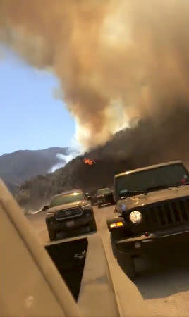 The pickup trucks escape from fire in Azusa, California, U.S., September 9, 2018 in this picture grab obtained from social media video. ANTONIO MEYER/via REUTERS