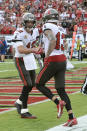 Tampa Bay Buccaneers quarterback Tom Brady (12) congratulates wide receiver Mike Evans (13) after Evans caught Brady's 600th career touchdown pass during the first half of an NFL football game Sunday, Oct. 24, 2021, in Tampa, Fla. (AP Photo/Jason Behnken)