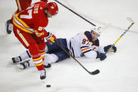 Calgary Flames' Josh Leivo (27) and Edmonton Oilers' Connor McDavid (97) battle for the puck during the second period of an NHL hockey game, Friday, Feb. 19, 2021 in Calgary, Alberta. (Todd Korol/The Canadian Press via AP)