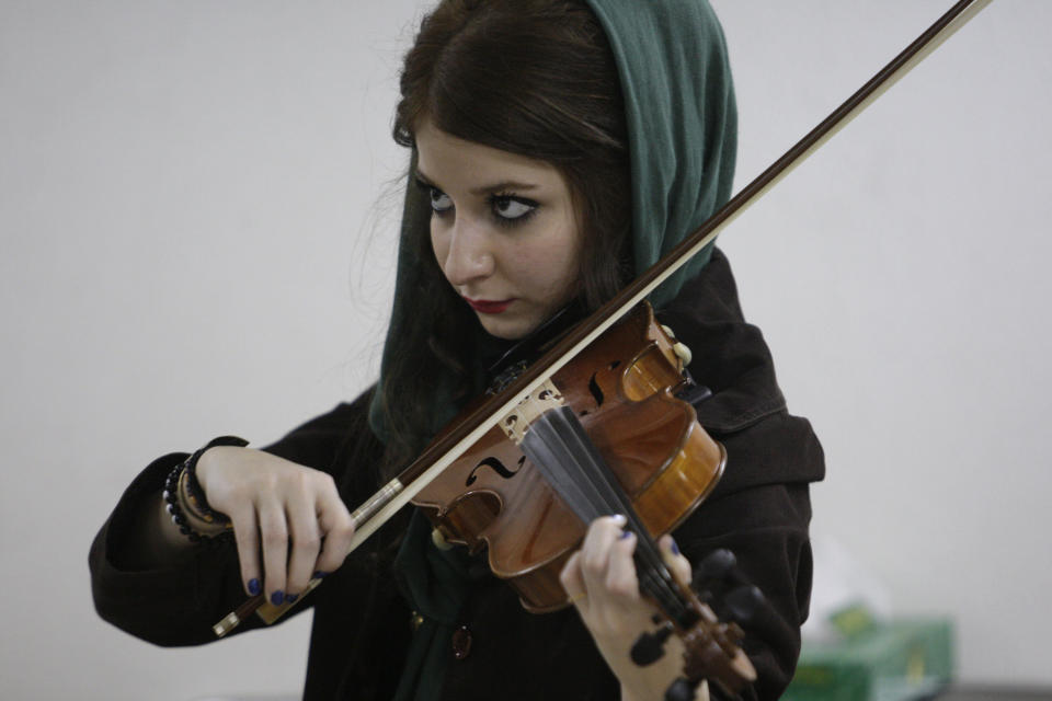 In this picture taken on Friday, Feb. 1, 2013, female Iranian violinist Nastaran Ghaffari practices for her band called "Accolade" in a basement of a house in Tehran, Iran. Heavy metal guitarists jamming in basements. Headphone-wearing disc jockeys mixing beats. It’s an underground music scene that is flourishing in Iran, despite government restrictions. (AP Photo/Vahid Salemi)