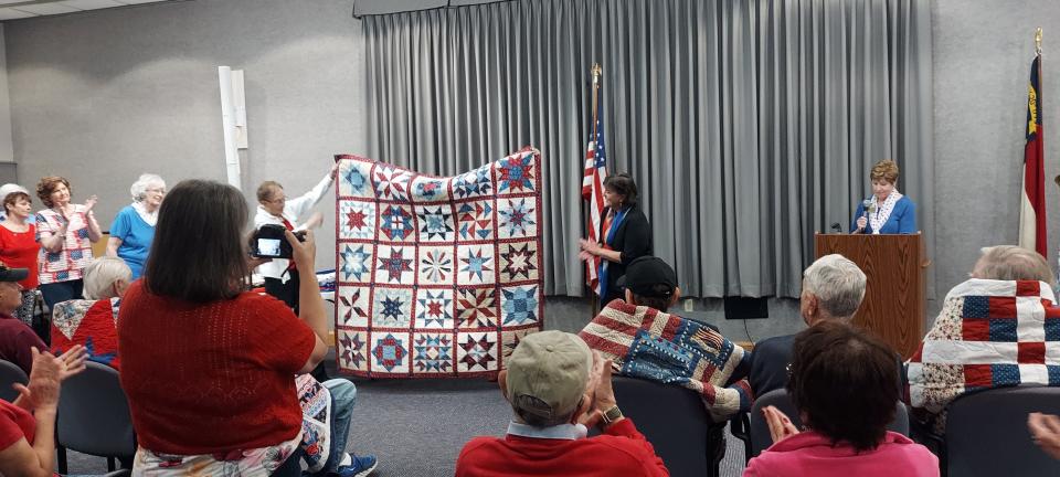 Stacie Litsenberger, US Army veteran (at right), sees her quilt for the first time on June 3.