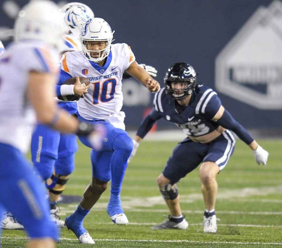 Boise State quarterback Taylen Green (10) runs downfield as Utah State defensive end Cian Slone, right, defends in the first half of an NCAA college football game Saturday, Nov. 18, 2023, in Logan, Utah. | Eli Lucero/The Herald Journal via AP