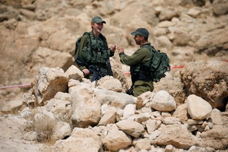 Israeli soldiers chat as they stand guard in the Jordan Valley, in the Israeli-occupied West Bank