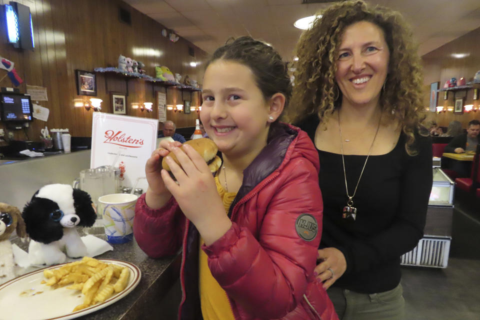 Evie Polera, left, and her mother Dara Polera, right, eat on March 5, 2024, at the counter of Holsten's, the Bloomfield N.J. ice cream parlor and restaurant where the final scene of "The Sopranos" TV series was filmed. A day earlier, the booth where Tony Soprano may or may not have met his end was sold in an online auction for $82,600 to a buyer that wishes to remain anonymous. (AP Photo/Wayne Parry)