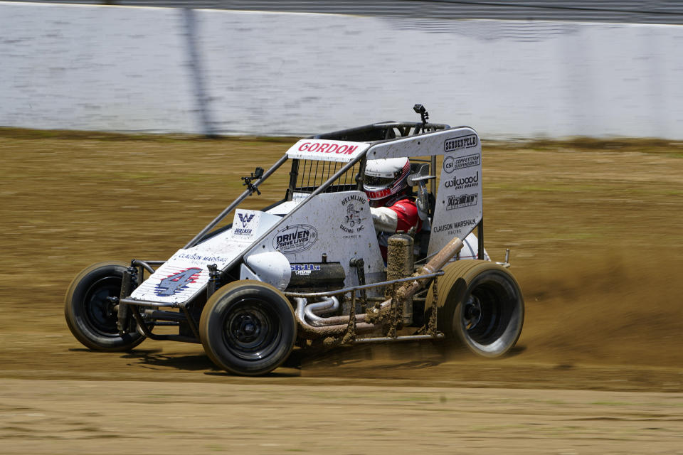 Jeff Gordon, a five-time winner of the Brickyard 400 and four-time NASCAR Cup Series champion, drives through a turn in a USAC midget car during an exhibition on the dirt track in the infield at Indianapolis Motor Speedway in Indianapolis, Thursday, June 17, 2021. (AP Photo/Michael Conroy)