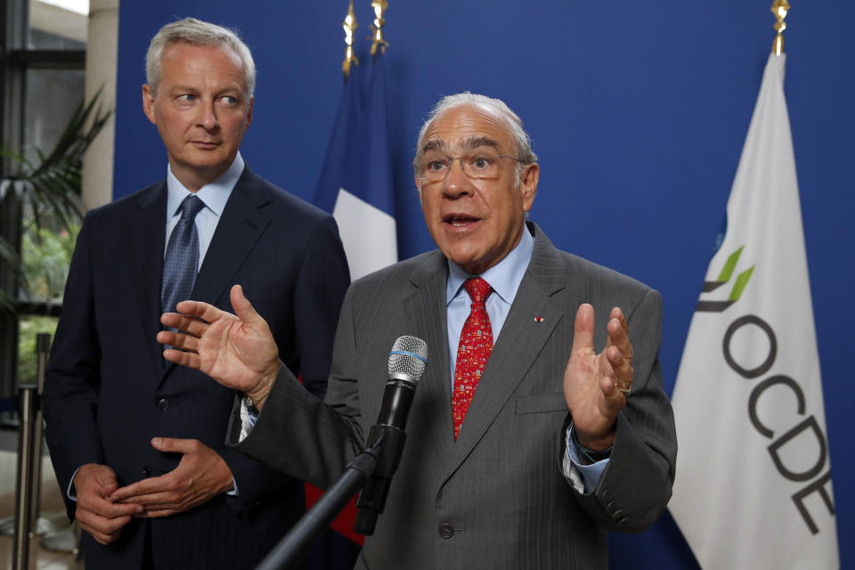 French Finance Minister Bruno Le Maire, left, attends a joint press conference with OECD chief Angel Gurria to plan for international taxes on digital giants like Amazon and Google at Bercy Economy ministry in Paris, Thursday, Aug. 29, 2019. France recently introduced a 3% tax on the companies' French revenues, prompting U.S. President Donald Trump to threaten tariffs on French wine in response.(AP Photo/Francois Mori)