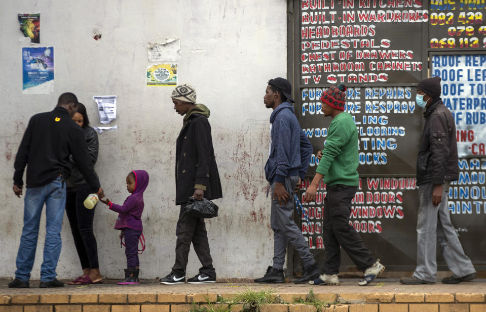 People queue for shopping at a local supermarket in Duduza, east of Johannesburg, South Africa, Thursday, April 2, 2020. South Africa went into a nationwide lockdown for 21 days in an effort to mitigate the spread to the coronavirus. The new coronavirus causes mild or moderate symptoms for most people, but for some, especially older adults and people with existing health problems, it can cause more severe illness or death. (AP Photo/Themba Hadebe)