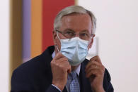 European Commission's Head of Task Force for Relations with the United Kingdom Michel Barnier puts on his protective face mask prior to meeting with European Council President Charles Michel at the EU Council building in Brussels, Friday, Sept. 18, 2020. (Yves Herman, Pool via AP)