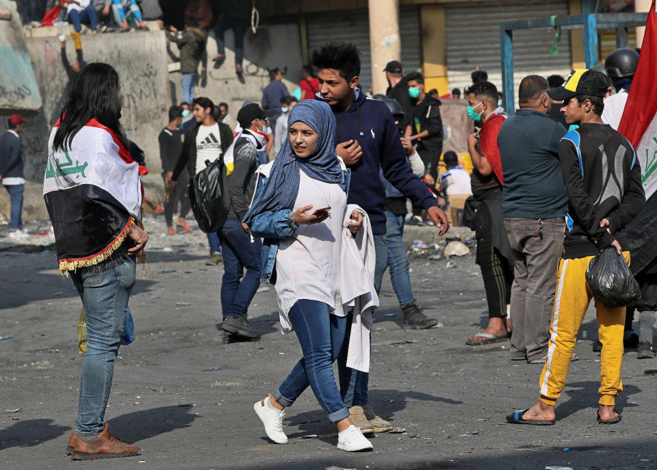 Anti-government protesters gather near barriers set up by security forces to close Rasheed Street during clashes in Baghdad, Iraq, Wednesday, Nov. 27, 2019. Several protesters were killed by security forces who fired live rounds in Baghdad and southern Iraq amid ongoing violence and days of sit-ins and road closures, Iraqi officials said Wednesday. (AP Photo/Khalid Mohammed)