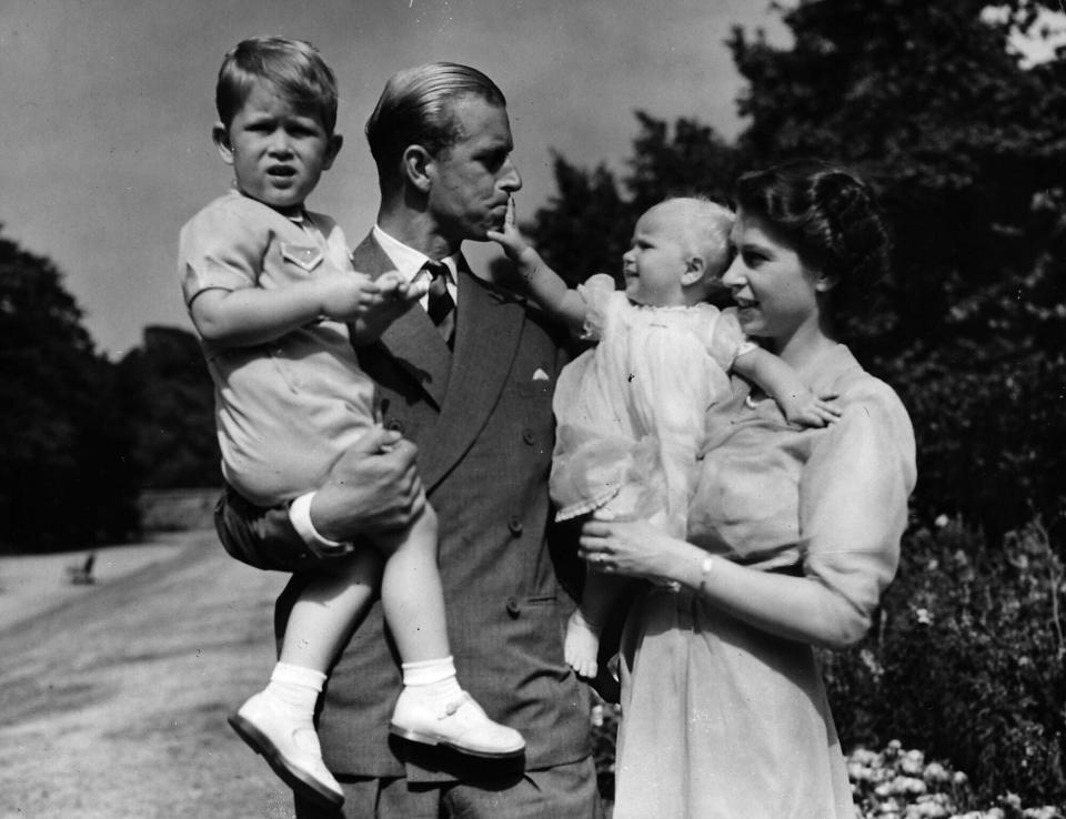 FILE - In this Aug. 1951 file photo, Princess Elizabeth stands with her husband the Duke of Edinburgh and their children Prince Charles and Princess Anne at the couple's London residence at Clarence House. Buckingham Palace says Prince Philip, husband of Queen Elizabeth II, has died aged 99. (AP Photo/Eddie Worth, file)