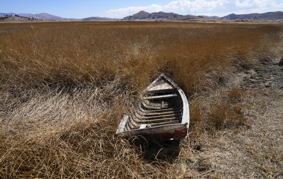 Una embarcación abandonada, cerca de la orilla del lago Titicaca, en Huarina, Bolivia, el 27 de julio de 2023. El bajo nivel del agua en el lago está teniendo un impacto directo en la flora y la fauna locales y afecta a las comunidades locales que dependen de la frontera natural entre Perú y Bolivia para su sustento. (AP Foto/Juan Karita)