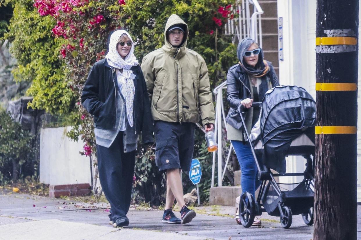 a group of people walking down a sidewalk