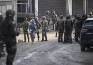 A Kashmiri woman walks past Indian security officers patrolling near the site of an attack on the outskirts of Srinagar, Indian controlled Kashmir, Thursday, Nov. 26, 2020. Anti-India rebels in Indian-controlled Kashmir Thursday killed two soldiers in an attack in the disputed region’s main city, the Indian army said.(AP Photo/Mukhtar Khan)