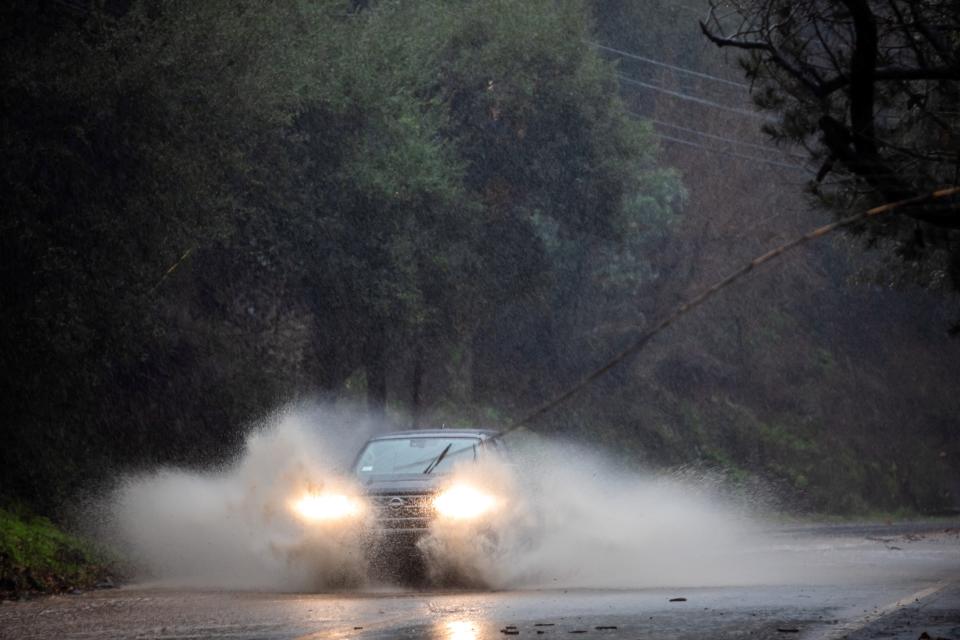 A car drives through a flooded road in Topanga, California, on February 4, 2024. The US West Coast was getting drenched on February 1 as the first of two powerful storms moved in, part of a u0022Pineapple Expressu0022 weather pattern that was washing out roads and sparking flood warnings. The National Weather Service said u0022the largest storm of the seasonu0022 would likely begin on February 4.