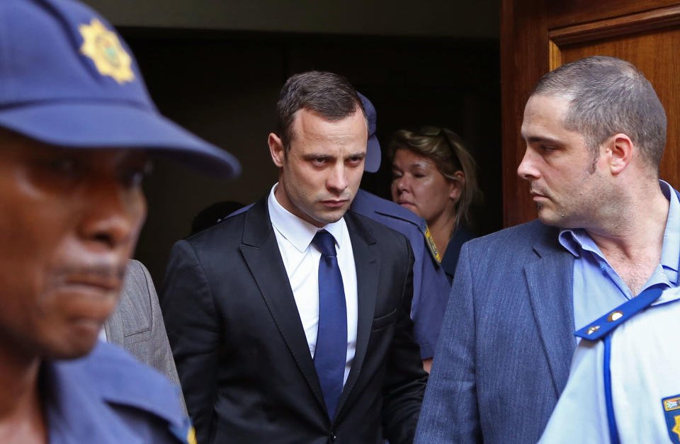 Oscar Pistorius, center, leaves the high court after the fourth day of his trial in Pretoria, South Africa, Thursday, March 6, 2014. Pistorius is charged with murder in the shooting death of girlfriend Reeva Steenkamp in the pre-dawn hours of Valentine's Day 2013. (AP Photo/Schalk van Zuydam)