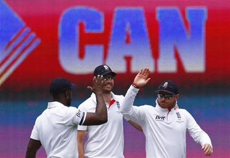 England's Ian Bell (R) celebrates with Michael Carberry (L) and James Anderson after taking a catch to dismiss Australia's captain Michael Clarke during the first day of the fifth Ashes cricket test match in Sydney January 3, 2014. REUTERS/David Gray