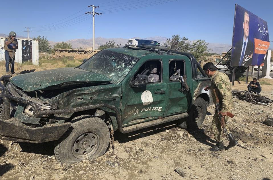 Afghan police inspect the site of a suicide attack, in Parwan province of Afghanistan, Tuesday, Sept. 17, 2019. The Taliban suicide bomber on a motorcycle targeted a campaign rally by President Ashraf Ghani in northern Afghanistan on Tuesday, killing over 20 people and wounding over 30. Ghani was present at the venue but was unharmed, according to his campaign chief. (AP Photo/Rahmat Gul)