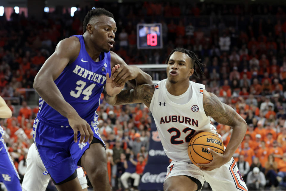 Auburn guard Allen Flanigan (22) is fouled by Kentucky forward Oscar Tshiebwe (34) as he goes to the basket during the second half of an NCAA college basketball game Saturday, Jan. 22, 2022, in Auburn, Ala. (AP Photo/Butch Dill)