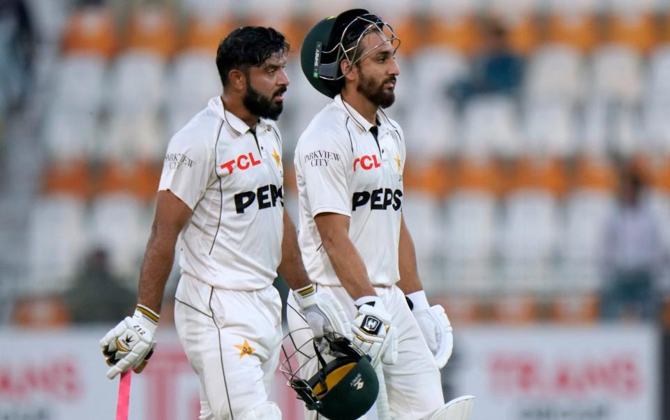 Pakistan's Aamer Jamal, left, and Salman Ali Agha walk off the field on the end of fourth day game of the first test cricket match between Pakistan and England, in Multan, Pakistan, Thursday, Oct. 10, 2024.