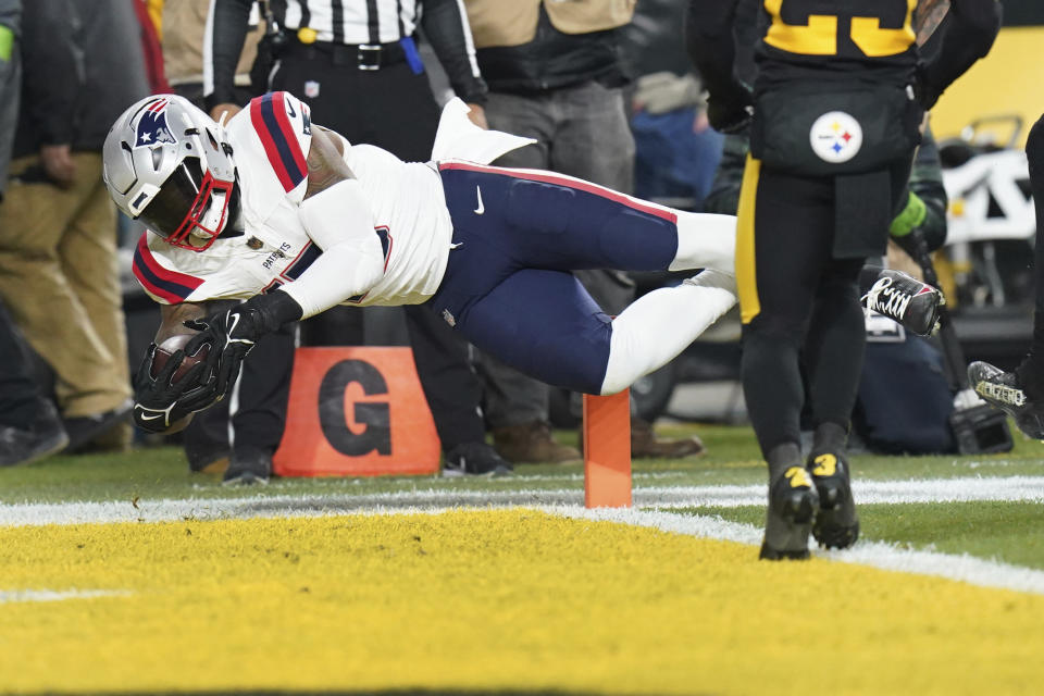 New England Patriots running back Ezekiel Elliott, left, scores during the first half of an NFL football game against the Pittsburgh Steelers on Thursday, Dec. 7, 2023, in Pittsburgh. (AP Photo/Matt Freed)