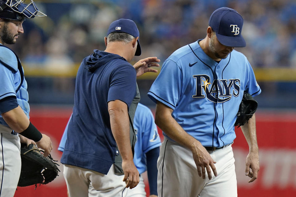 Tampa Bay Rays manager Kevin Cash, center, takes starting pitcher Rich Hill, right, out of the game against the Baltimore Orioles during the fourth inning of a baseball game Saturday, June 12, 2021, in St. Petersburg, Fla. Looking on is catcher Mike Zunino. (AP Photo/Chris O'Meara)