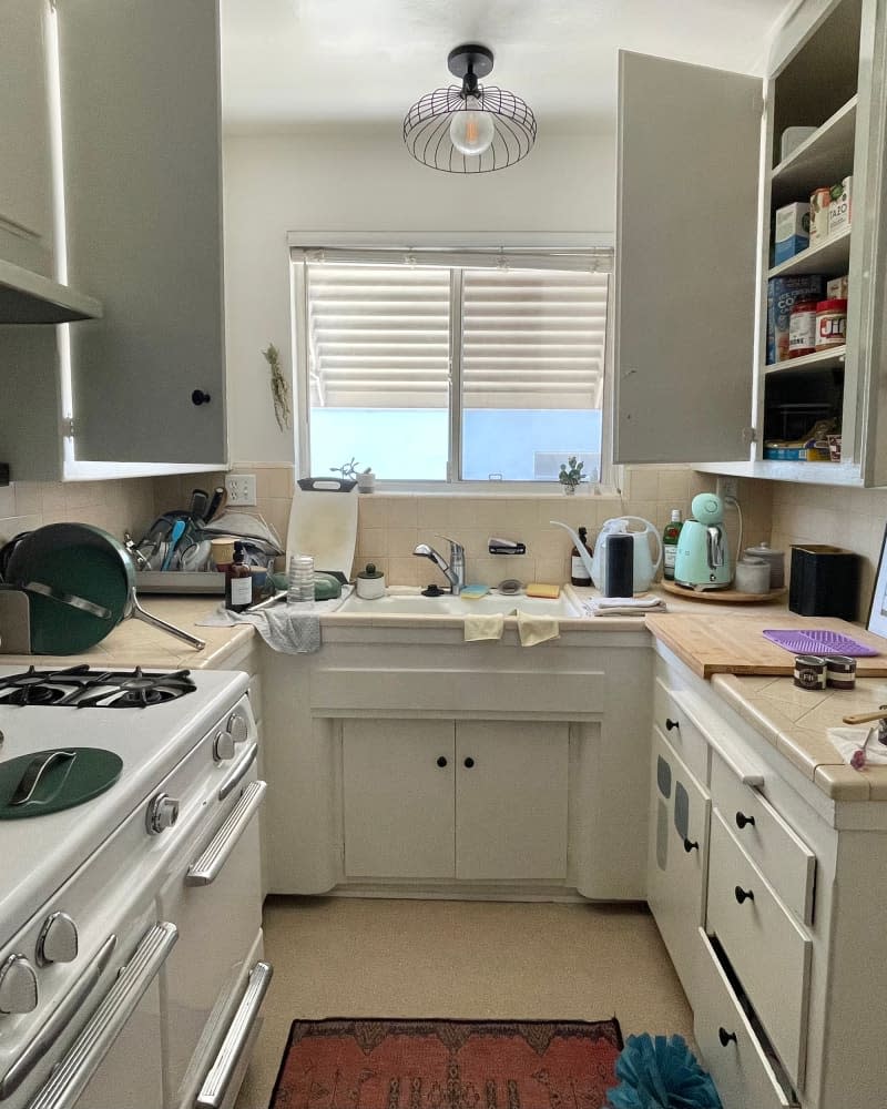 Vintage white cabinets in kitchen before renovation.