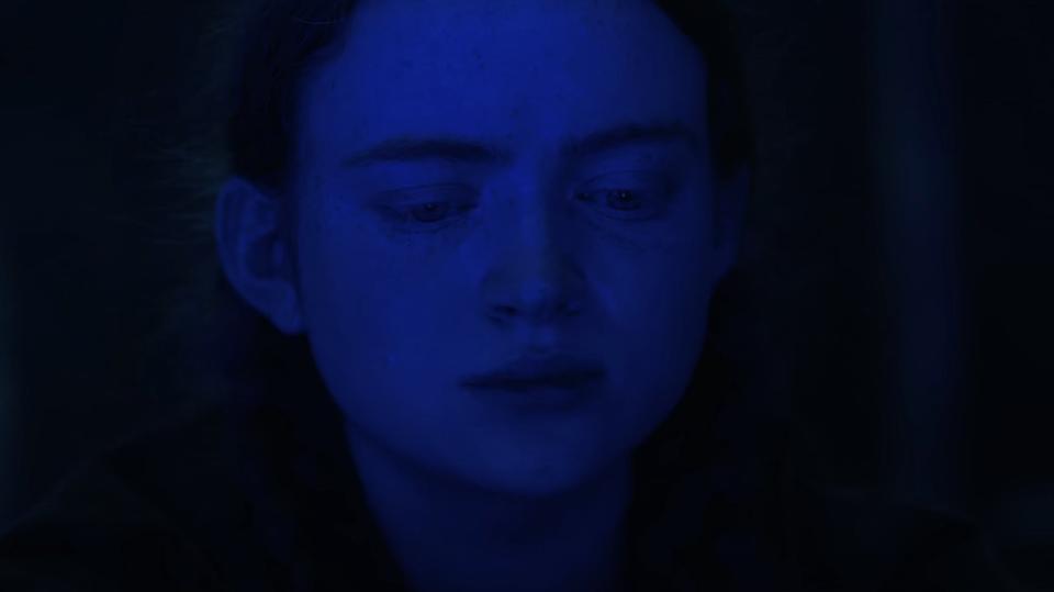 Max with her face illuminated by blue light in "Stranger Things"