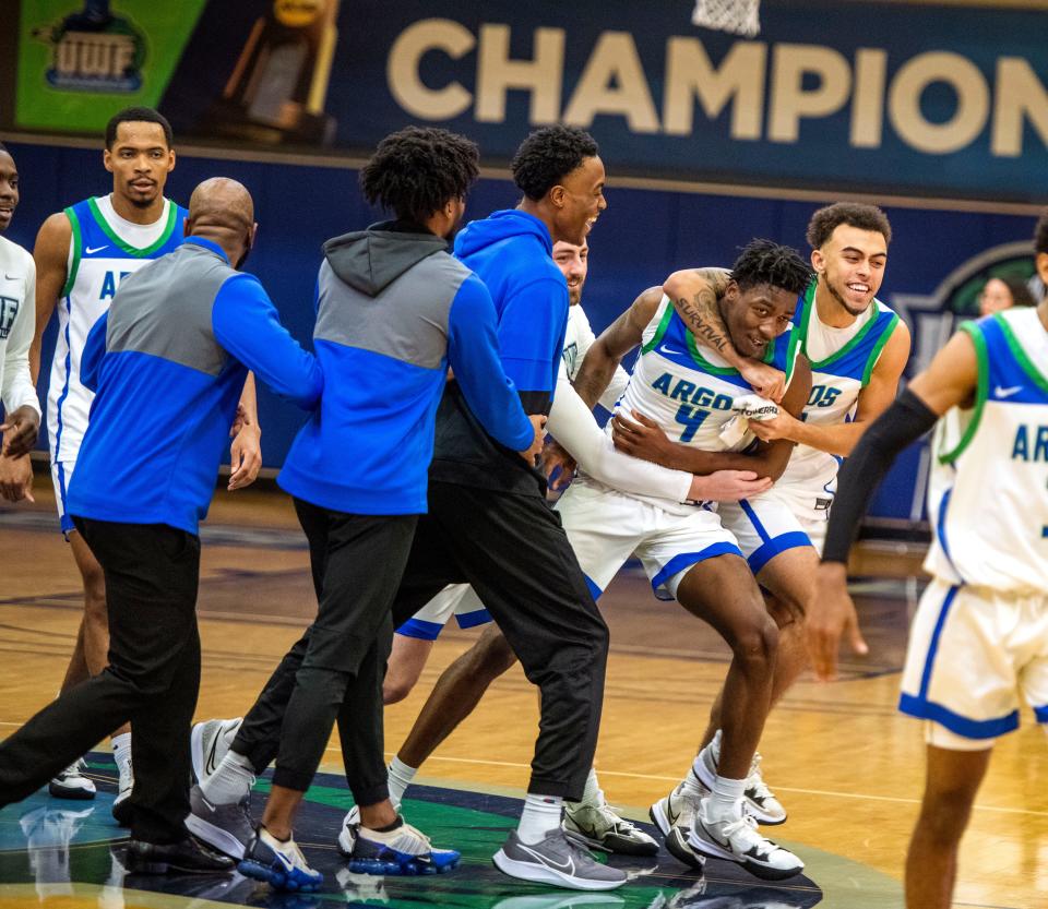 The University of West Florida basketball team celebrates after beating Valdosta State in overtime 99-97 at The UWF Fieldhouse Saturday, January 8, 2022.