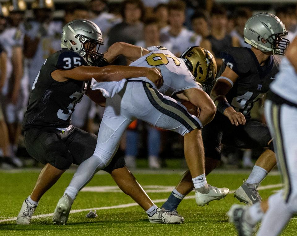 Jasper’s Carter Holsworth (6) is tackled by Reitz’s Levi Oxley (35) as the Reitz Panthers play the Jasper Wildcats at the Reitz Bowl in Evansville, Ind., Friday evening, Sept. 2, 2022. 