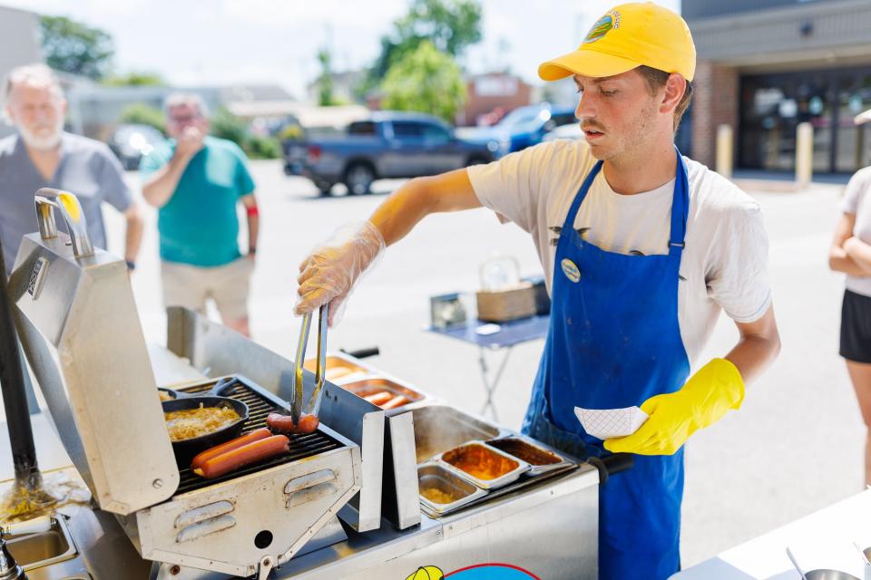 Connor Eisenhart, owner of The Homedog LLC, slings hotdogs from his hot dog cart in the parking lot of W.E. Sell Sporting Goods on the corner of Pleasant Street and York Street, Tuesday, May 21, 2024, in Hanover Borough.