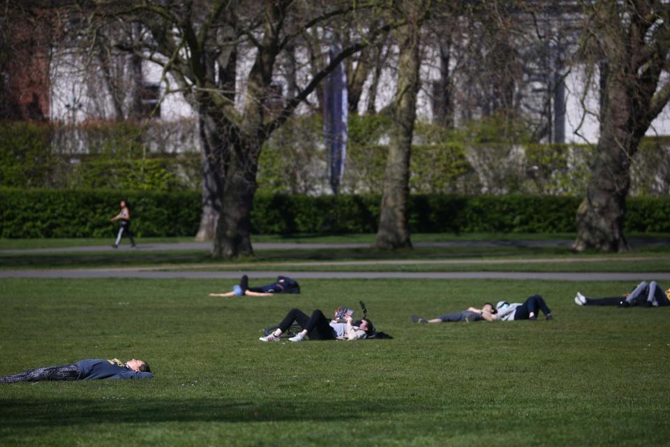 People pictured lying in the sun in Greenwich Park (REUTERS)