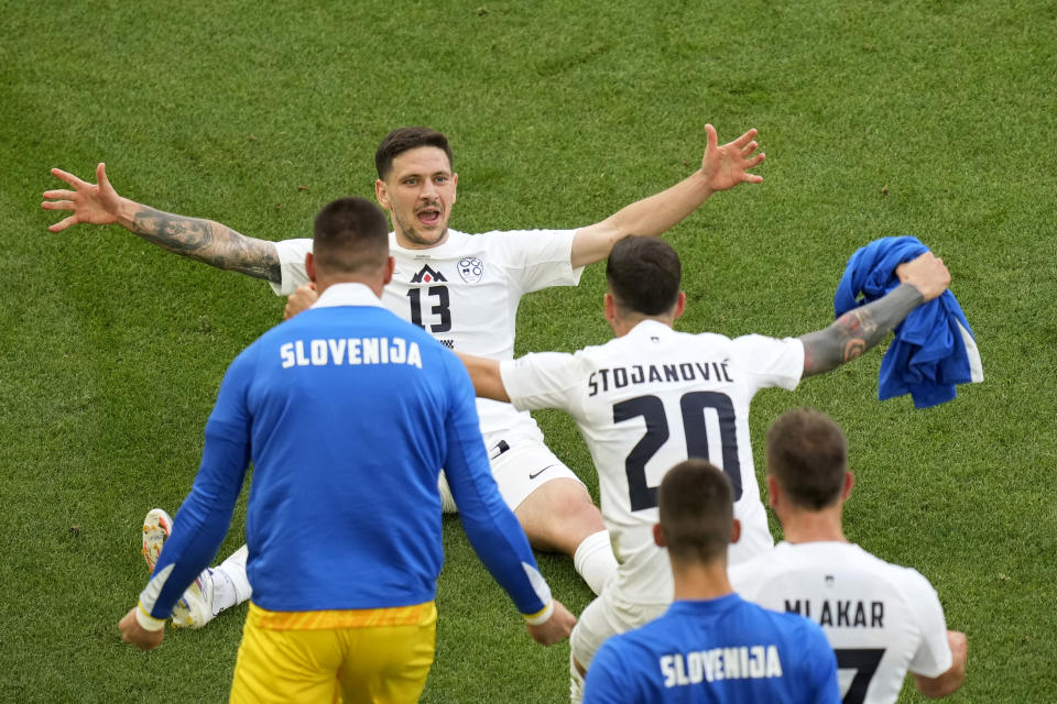 Slovenia's Erik Janza, on the ground, celebrates after scoring his side's first goal during a Group C match between Slovenia and Denmark at the Euro 2024 soccer tournament in Stuttgart, Germany, Sunday, June 16, 2024. (AP Photo/Ariel Schalit)