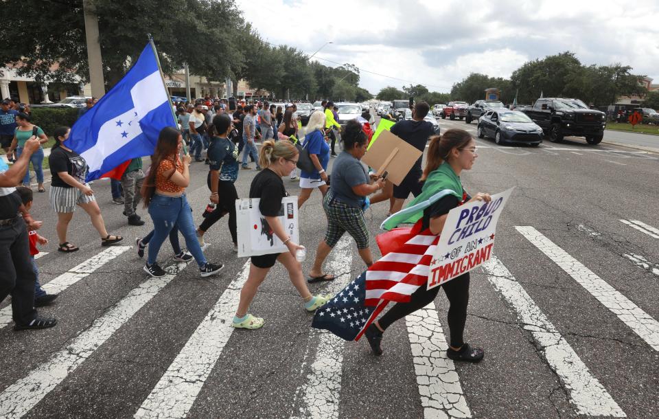 Manifestantes cruzan una calle, el jueves 1 de junio de 2023, en Orlando, Florida, durante una protesta contra la nueva ley de inmigración de Florida que promulgó el gobernador Ron DeSantis. (Joe Burbank/Orlando Sentinel via AP)