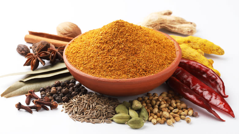 Curry powder in a bowl surrounded by spices 